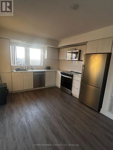 Toronto (Etobicoke West Mall) condo for rent - A kitchen with a refrigerator, oven, and sink.