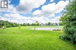 Waterloo apartment for rent - A green field with a white fence and a blue sky with clouds.