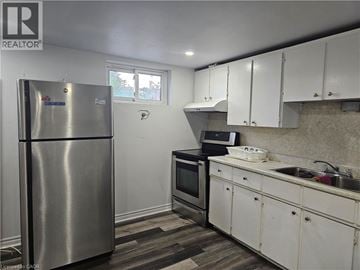 Hamilton apartment for rent - A kitchen with white cabinets and a stainless steel refrigerator.