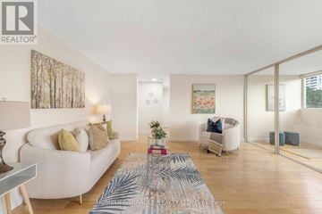 Mississauga (Mississauga Valleys) condo for rent - A living room with a white couch and a rug with a pattern on it.