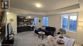 Hamilton (Waterdown) townhouse for rent - A living room with a couch, a table, and a television.