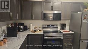 Hamilton (Waterdown) townhouse for rent - A kitchen with a refrigerator, oven, and microwave.