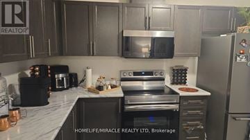 Hamilton (Waterdown) townhouse for rent - A kitchen with a refrigerator, oven, and microwave.