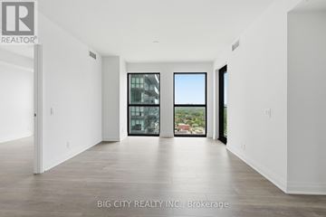 Toronto (Thorncliffe Park) condo for rent - A spacious room with a view of the city through a large window.