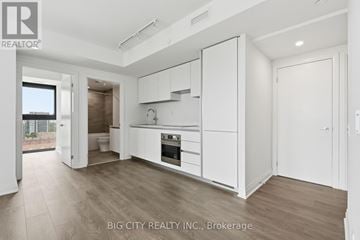 Toronto (Thorncliffe Park) condo for rent - A spacious kitchen with white cabinets and a wooden floor.