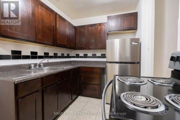 Toronto (Stonegate-Queensway) condo for rent - A kitchen with a stove and a refrigerator.