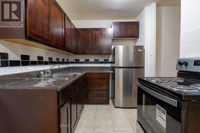 Toronto (Stonegate-Queensway) condo for rent - A kitchen with a refrigerator, stove, and sink.
