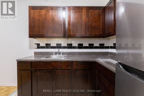 Toronto (Stonegate-Queensway) condo for rent - A kitchen with wooden cabinets and a sink.