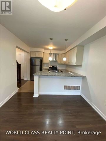 Oakville (Go Glenorchy) townhouse for rent - A kitchen with a countertop and cabinets in a room with wooden floors.