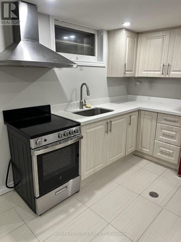 Toronto (Woburn) apartment for rent - A kitchen with a black stove and white cabinets.