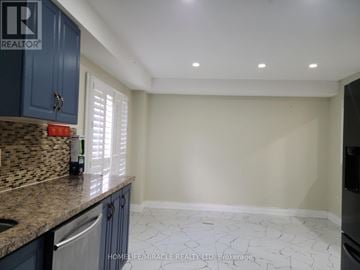 Brampton (Sandringham-Wellington) townhouse for rent - A kitchen with blue cabinets and a tiled backsplash.