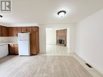 Toronto (Yorkdale-Glen Park) apartment for rent - A kitchen with a white refrigerator and wooden cabinets.