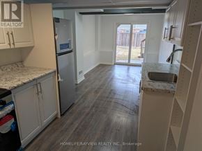 Innisfil (Alcona) townhouse for rent - A kitchen with white cabinets and a granite countertop.