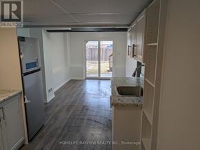 Innisfil (Alcona) townhouse for rent - A kitchen with a refrigerator, sink, and cabinets.