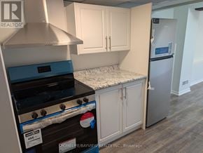 Innisfil (Alcona) townhouse for rent - A kitchen with a stove top oven and a refrigerator.