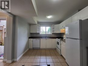 Coquitlam apartment for rent - A kitchen with white appliances and cabinets.