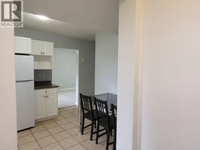 Coquitlam apartment for rent - A kitchen with a table and chairs in the foreground and a refrigerator in the background.