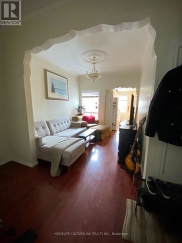 Toronto (Niagara) townhouse for rent - A living room with a white couch and a guitar leaning against the wall.