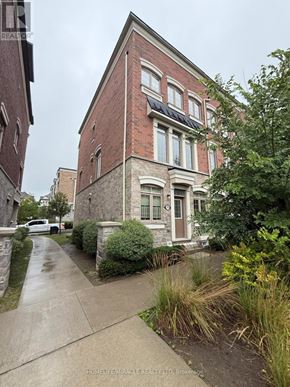 Ajax (Central) townhouse for rent - A brick building with a white van parked in front.