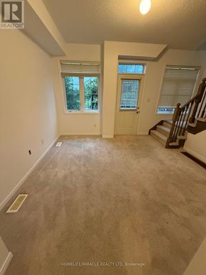 Ajax (Central) townhouse for rent - A spacious room with a staircase on the right side.