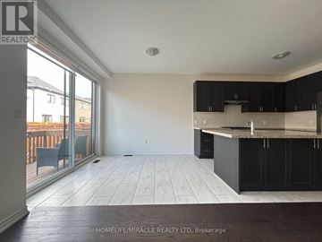 Caledon apartment for rent - A spacious kitchen and living room with black cabinets and a marble countertop.