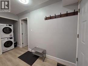 Coquitlam apartment for rent - A laundry room with a washer and dryer and a black mat on the floor.