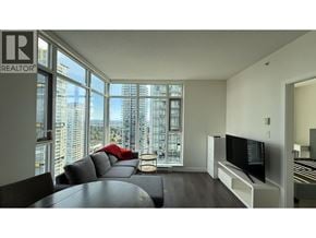 Burnaby apartment for rent - A living room with a large window overlooking a cityscape.