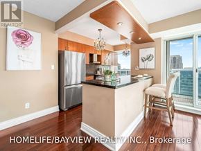 Toronto (Willowdale East) condo for rent - A kitchen with a refrigerator, a counter, and a chair.