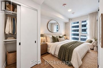 Toronto (Niagara) condo for rent - A bedroom with a large bed and a mirror on the wall.