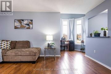 Wasaga Beach apartment for rent - A living room with a couch, a table with a lamp, and a painting on the wall.