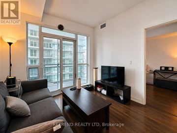 Toronto (Mount Pleasant West) condo for rent - A living room with a grey couch and a wooden coffee table.