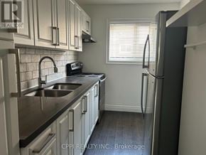 Toronto (Don Valley Village) townhouse for rent - A kitchen with a sink, stove, and refrigerator.