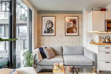 Toronto (Moss Park) condo for rent - A living room with a grey couch and two framed pictures on the wall.