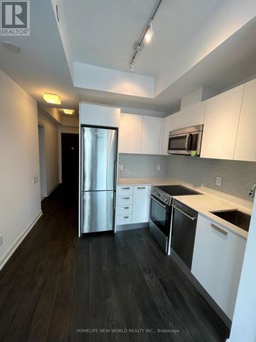 Toronto (Church-Yonge Corridor) condo for rent - A kitchen with white cabinets and black appliances.