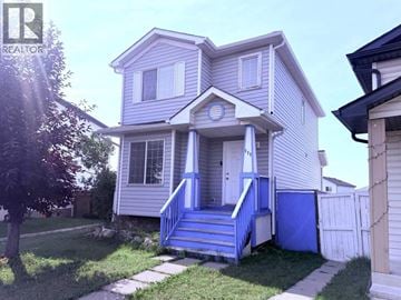 Calgary apartment for rent - A house with a blue front porch and steps.