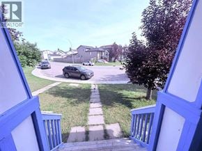 Calgary apartment for rent - A car is parked on a street in front of a house.