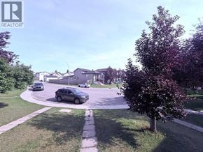 Calgary apartment for rent - A residential street with cars parked on the side.