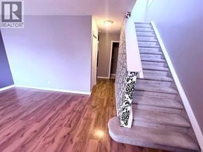 Calgary apartment for rent - A staircase with a black and white patterned runner leads up to a door.