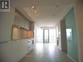 Toronto (Church-Yonge Corridor) condo for rent - A spacious kitchen with white cabinets and a large window.