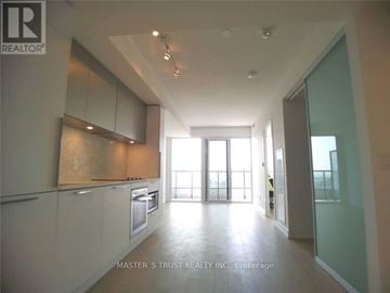 Toronto (Church-Yonge Corridor) condo for rent - A spacious kitchen with white cabinets and a large window.