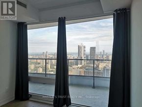 Toronto (Church-Yonge Corridor) condo for rent - A room with a view of the city skyline through a window with curtains.