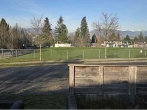 Surrey apartment for rent - A wooden fence in the foreground with a grassy field and trees in the background.