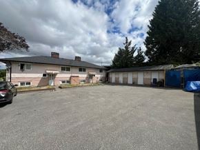Surrey apartment for rent - A car is parked in a gravel lot in front of a house.