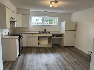 Surrey apartment for rent - A kitchen with a black dishwasher and white cabinets.