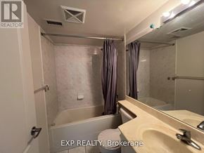 Toronto (Bendale) condo for rent - A bathroom with a tub, sink, and mirror.