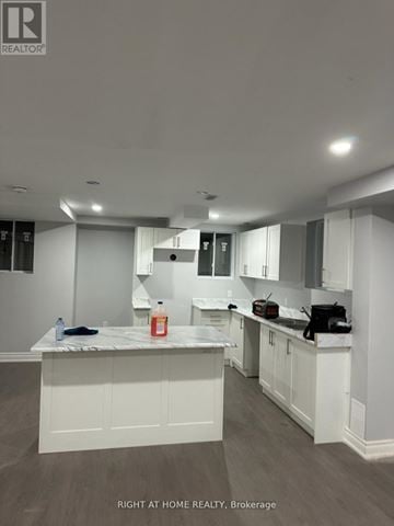 Bradford West Gwillimbury (Bradford) apartment for rent - A kitchen with white cabinets and a marble countertop.
