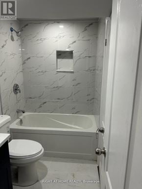 Bradford West Gwillimbury (Bradford) apartment for rent - A white bathroom with a marble wall and a bathtub.