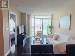 Toronto (Willowdale East) condo for rent - A living room with a couch, chair, and television.