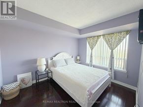 Toronto (Willowdale East) condo for rent - A bedroom with a bed, nightstand, and window.