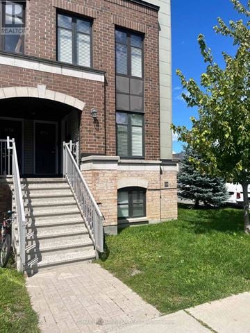 Ottawa townhouse for rent - A building with a brick facade and a set of stairs leading to the entrance.